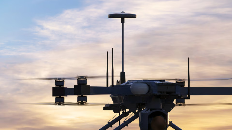 Multi-rotor drone with communications payload against a sunset sky